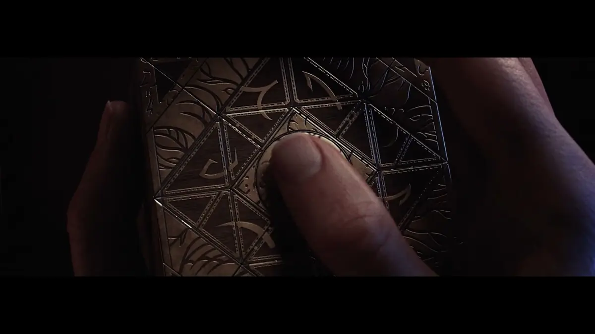 Close-up of a thumb resting on the engraved panels of the Genesis Configuration
