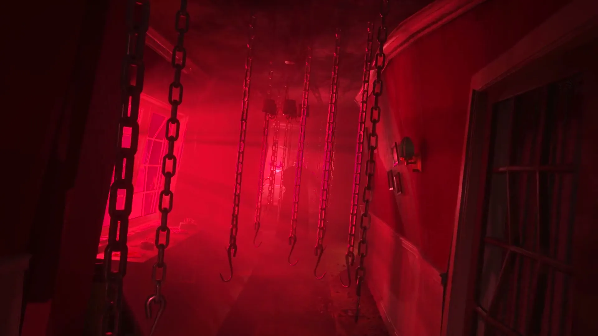Red-lit corridor hung with chains and meat hooks in Hellraiser Revival